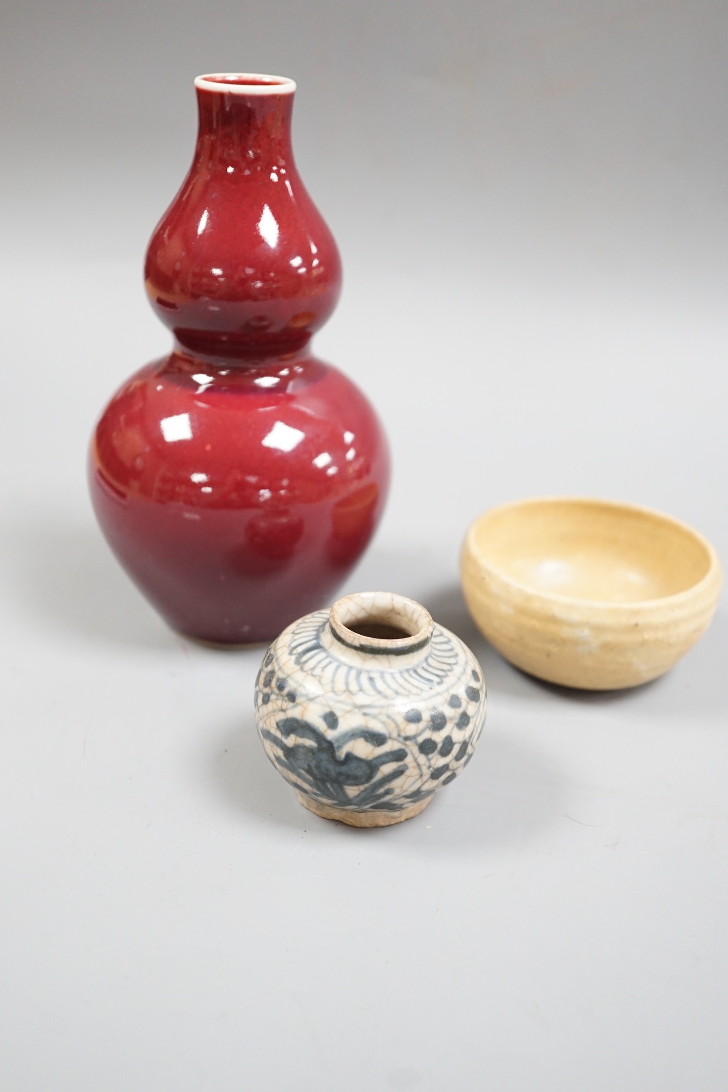 A Chinese sang de boeuf double gourd vase, a Swatow blue and white jarlet and a small cup, tallest 17cm